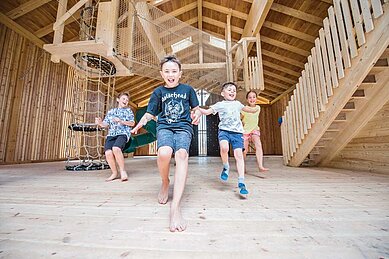 Kinder spielen in der geräumigen Spielhalle des Familienhotels Huber in Südtirol
