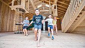Kinder spielen in der geräumigen Spielhalle des Familienhotels Huber in Südtirol
